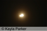 Photo of the full moon taken hand-held with long exposure so there's a trace of movement described in the sky